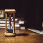 Ampulheta sobre moldura de madeira, simbolizando a passagem do tempo e o memento mori
