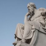 Estatua de filosofo grego em pose reflexiva, simbolizando o estoicismo