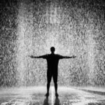 Amor fati: silhueta de homem em pé sob a chuva, simbolizando aceitar o destino