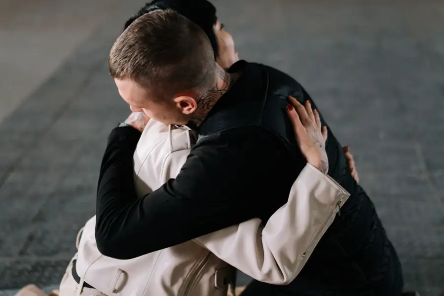 Duas pessoas se abraçando com força, em sinal de reconciliação