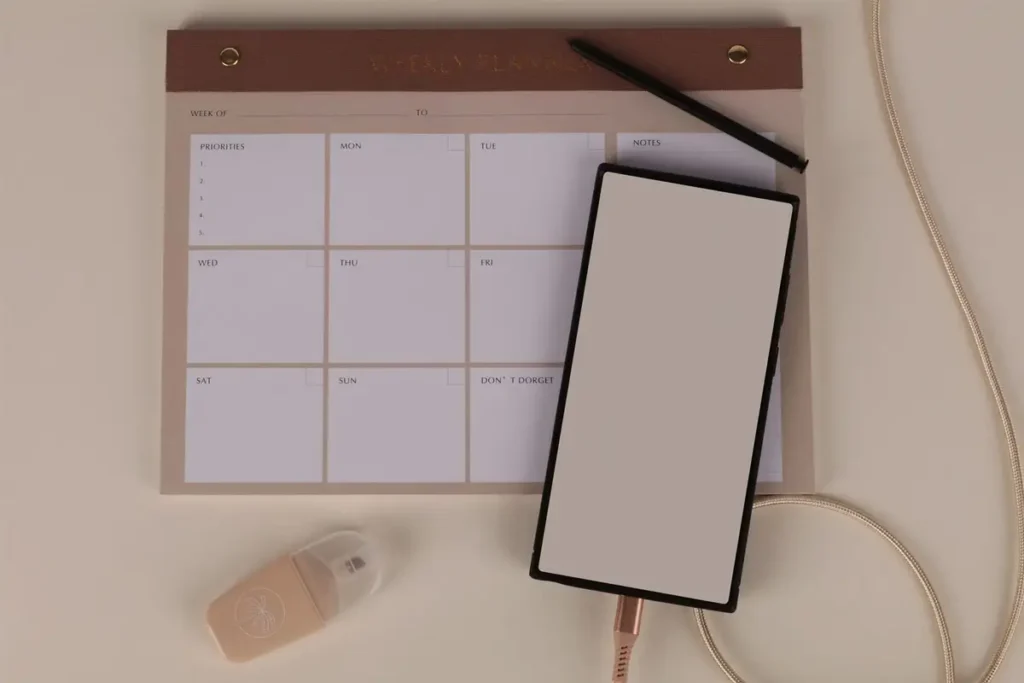 Mesa de trabalho com planner semanal e celular, tema de estoicismo e produtividade