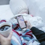 Pessoa usando o celular com calma e uma xícara de café, tema de estoicismo e redes sociais