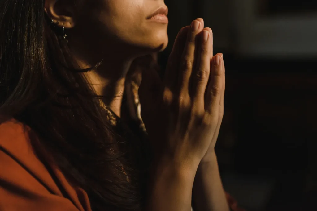 Mãos em oração representando fé ao lado do estoicismo e religião