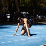 Atleta concentrada na largada de uma pista de corrida, tema de estoicismo no esporte