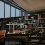Estudante concentrado numa biblioteca cheia de livros, tema de estoicismo para estudantes