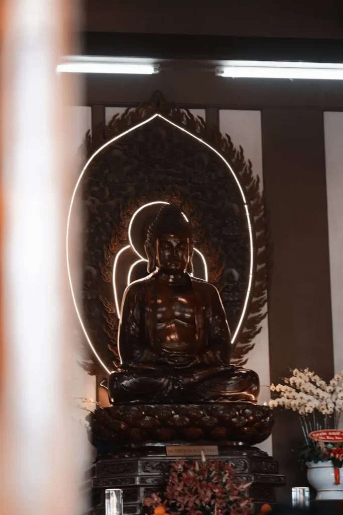 Estátua de Buda iluminada numa sala de meditação, tema de estoicismo x budismo