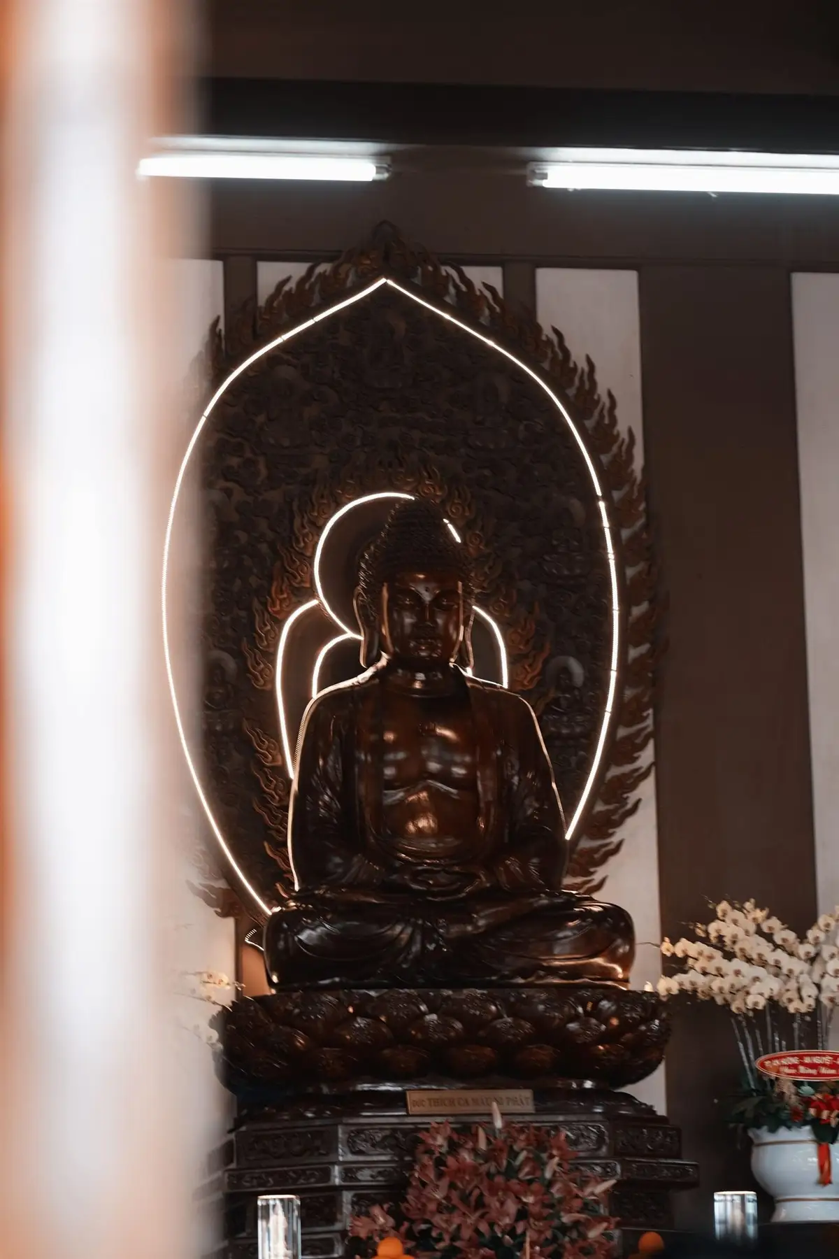 Estátua de Buda iluminada numa sala de meditação, tema de estoicismo x budismo