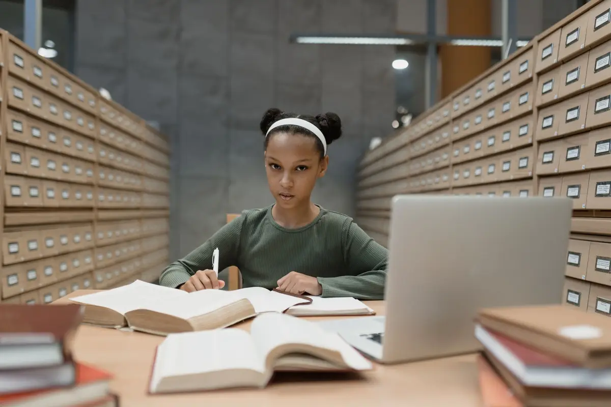 Estudante com livros abertos e notebook, aplicando estoicismo para estudantes na rotina