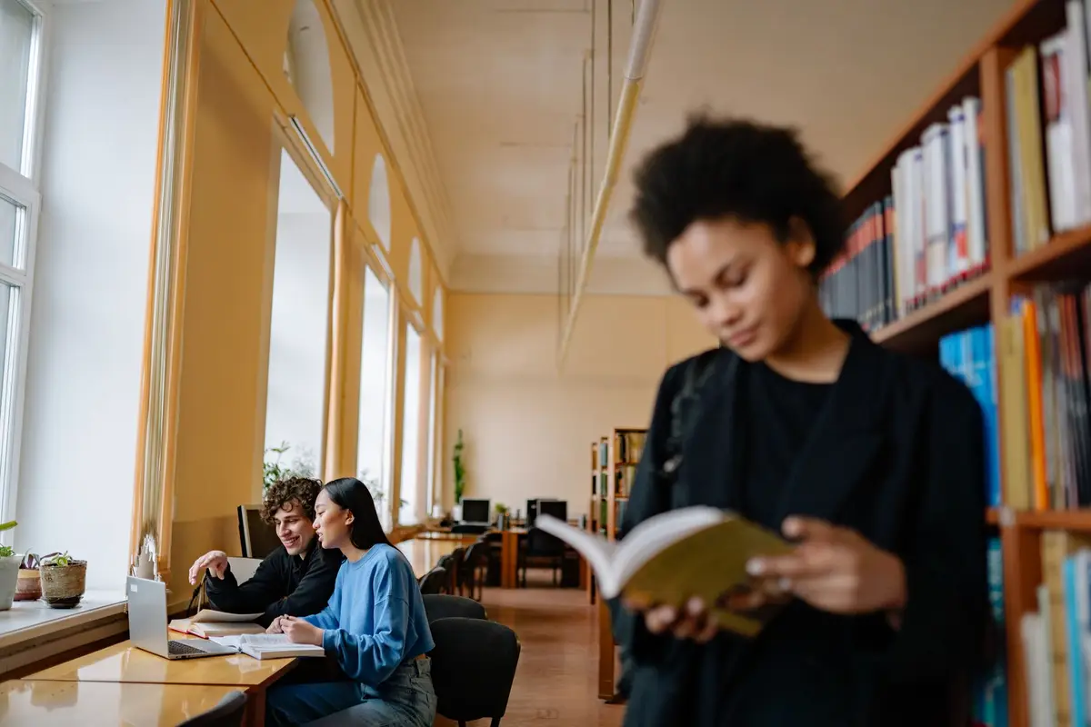 Estudantes lendo e estudando na biblioteca da universidade