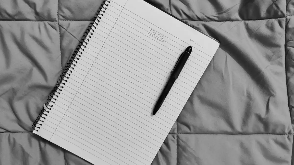Lista de tarefas curta num caderno com caneta, estoicismo e produtividade na prática