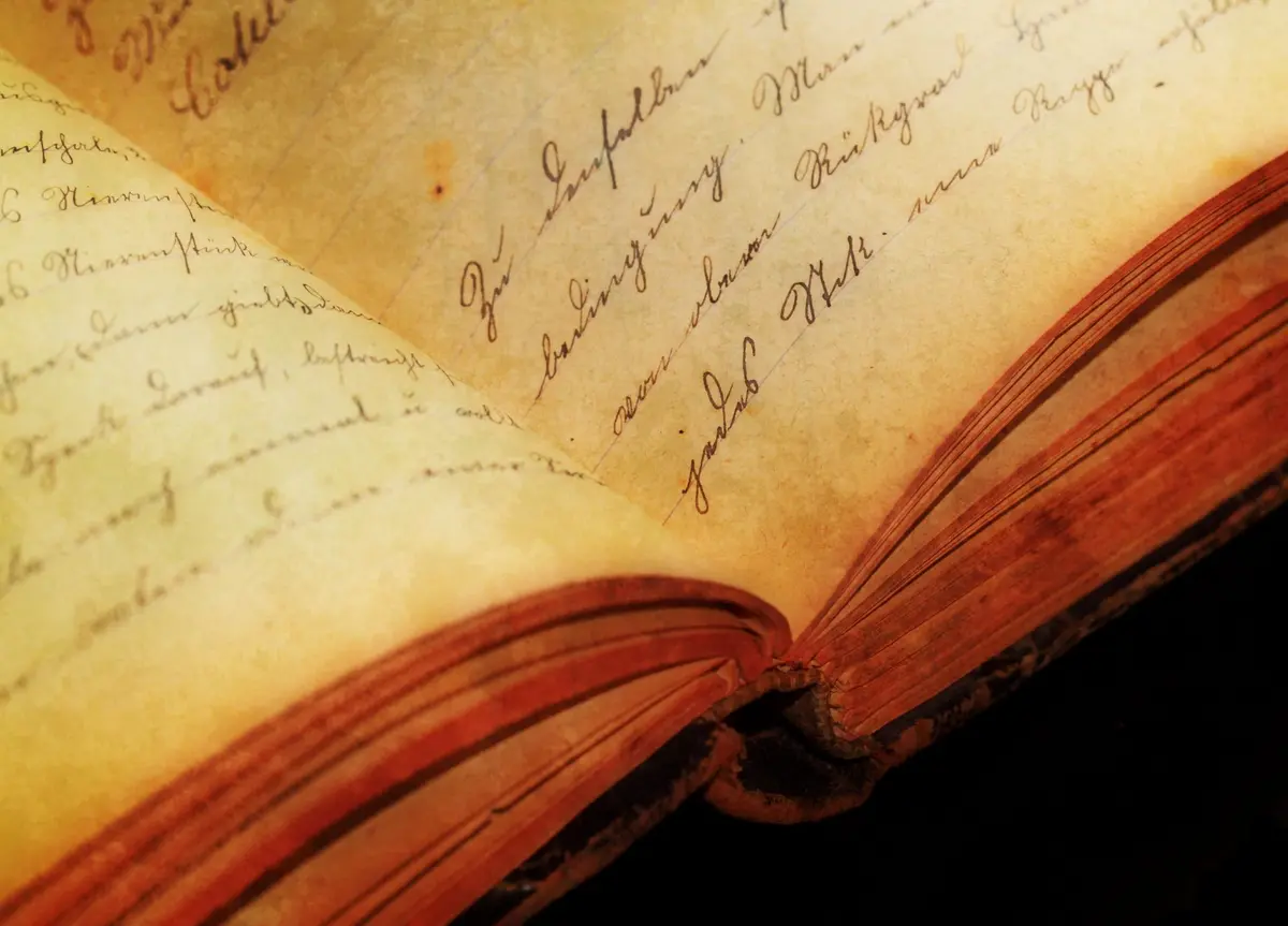 Livro antigo aberto com páginas escritas à mão