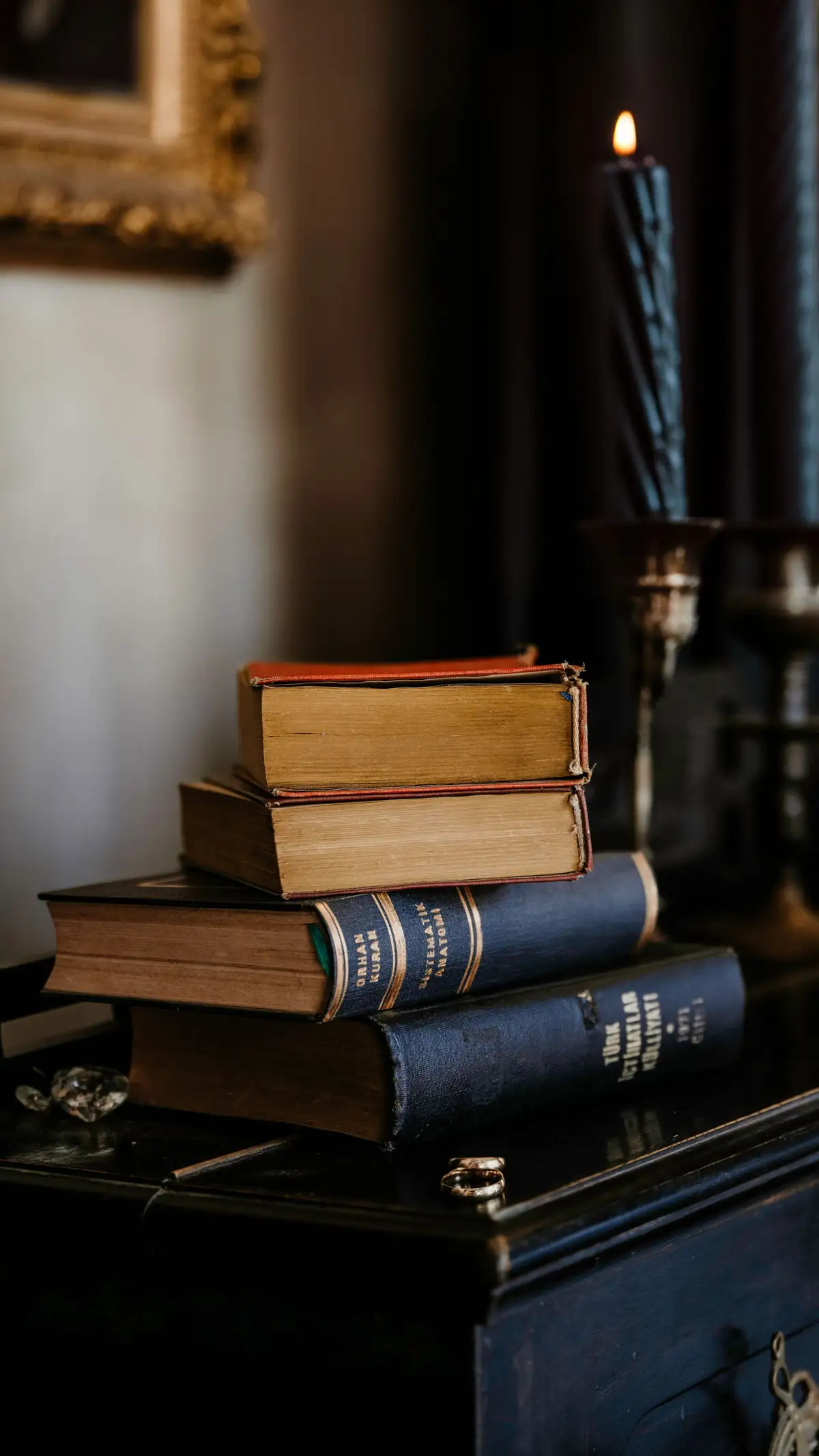 Livros antigos e vela acesa, lembrando a última noite de Catão o Jovem lendo o Fédon, de Platão