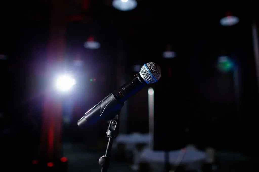 Microfone no palco sob a luz do refletor, tema do medo de falar em público