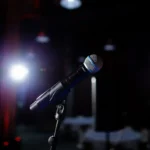 Microfone no palco sob a luz do refletor, tema do medo de falar em público