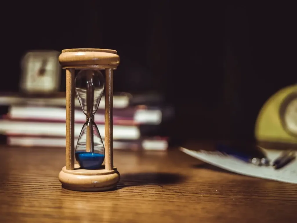 Ampulheta sobre a mesa, símbolo da passagem do tempo e do memento mori