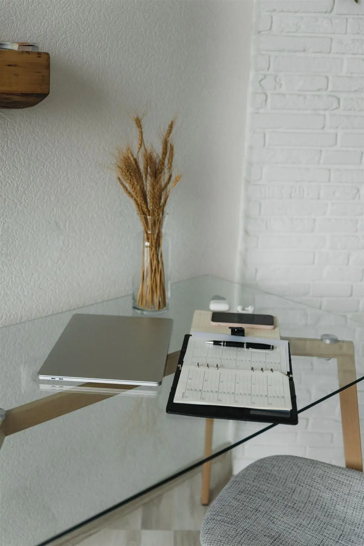 Mesa simples com notebook e caderno, apenas o necessário para trabalhar