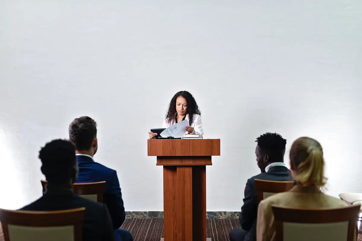 Mulher discursando com calma para a plateia, vencendo o medo de falar em público