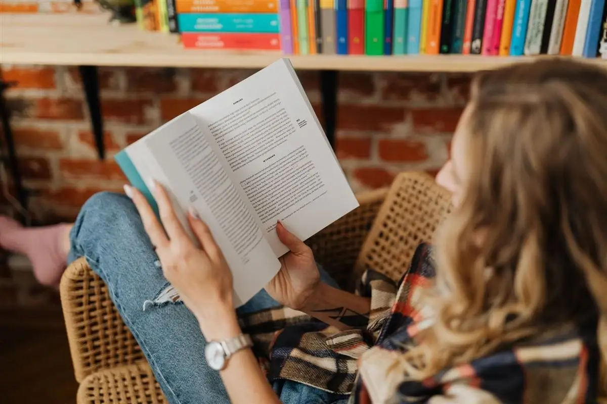 Mulher lendo um livro na poltrona, começando pelos livros de estoicismo