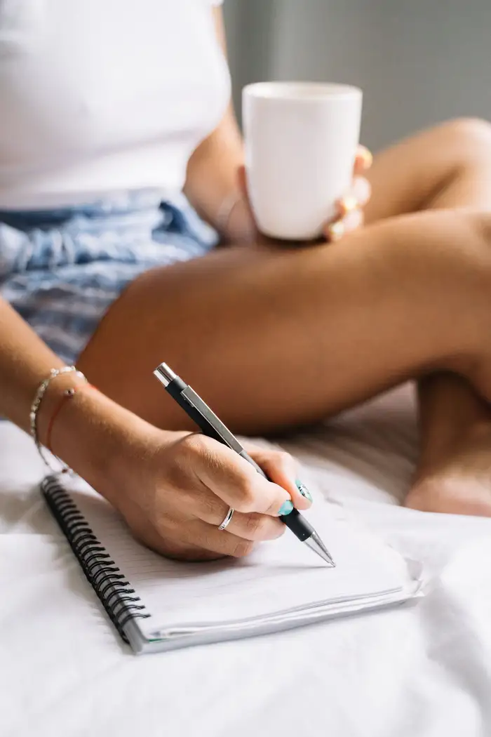 Pessoa escrevendo num caderno de manhã, separando o que controla do que não controla