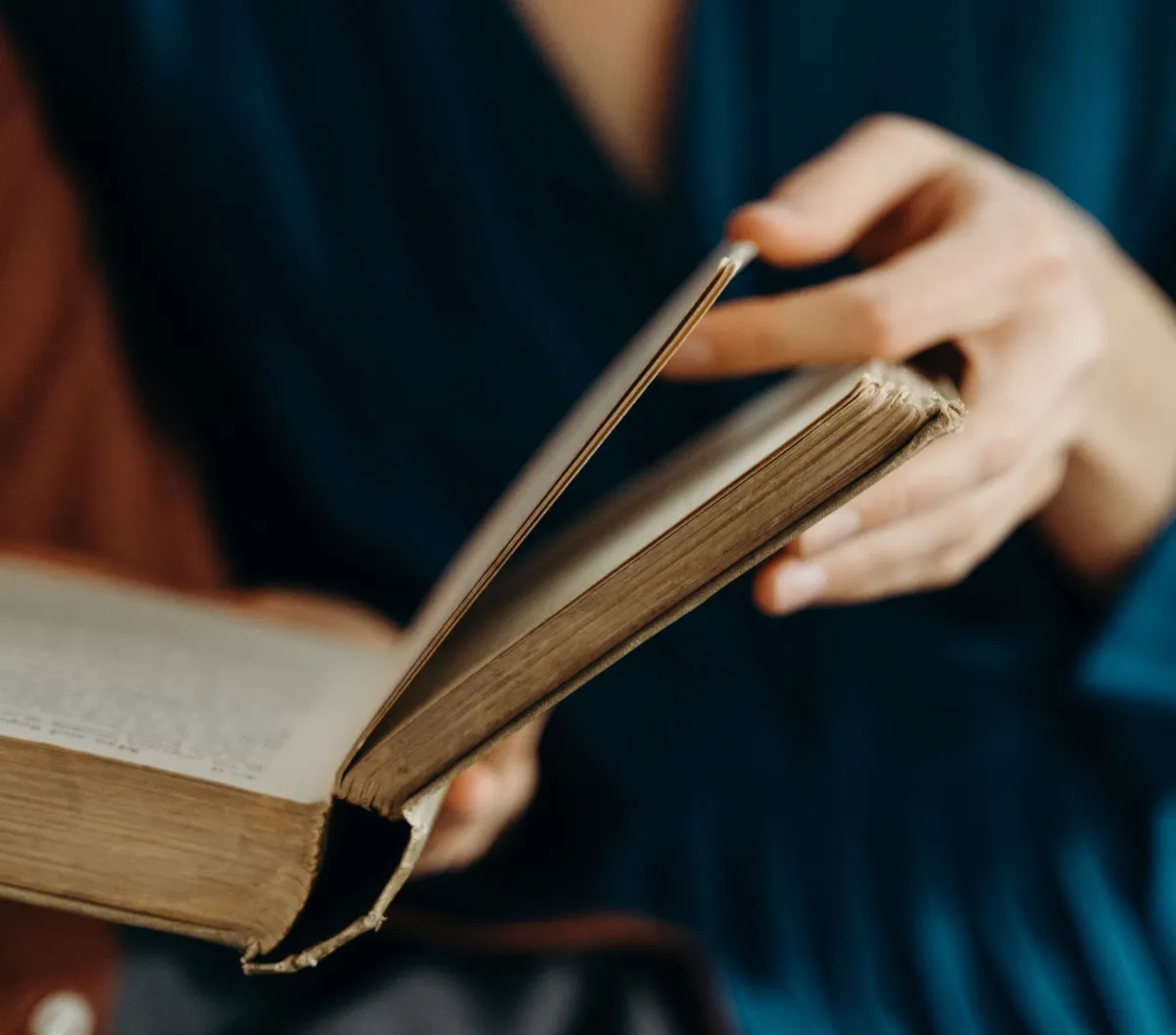 Pessoa folheando um livro antigo em busca de frases de Sêneca