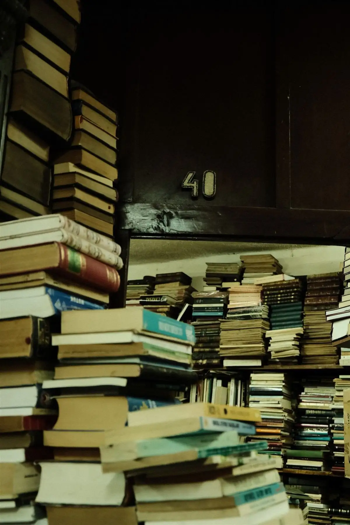 Pilhas de livros antigos numa biblioteca, as obras que mostram quem foi Sêneca