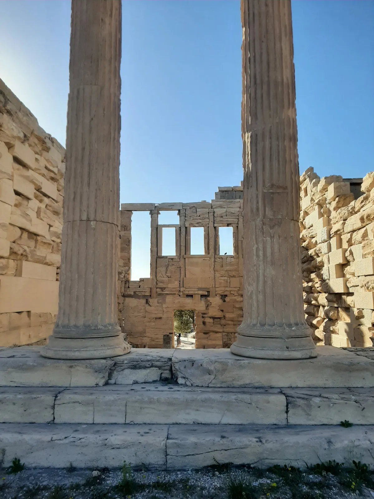 Colunas de ruínas gregas antigas em Atenas sob céu azul