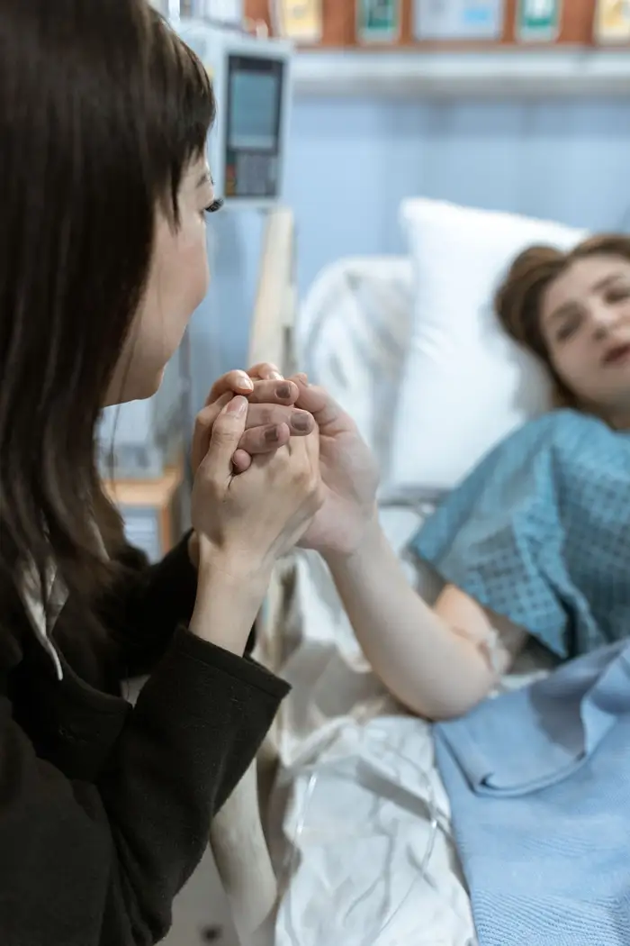 Visita segurando a mão de uma paciente no hospital, apoio no encontro entre estoicismo e doença