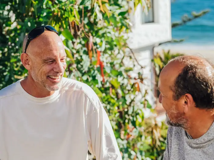 Dois amigos rindo ao ar livre num dia de sol, retrato de estoicismo e gratidão no cotidiano