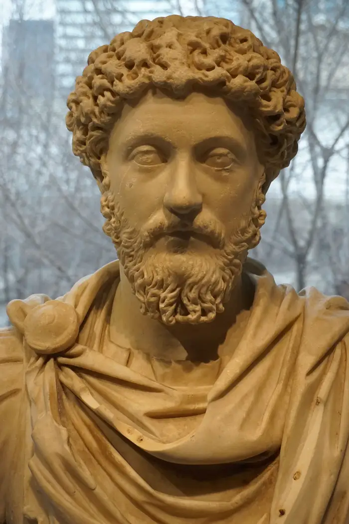 Busto antigo de imperador romano barbado, de cabelos cacheados