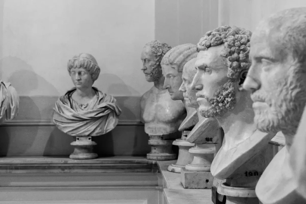 Fileira de bustos antigos de mármore em museu, em preto e branco