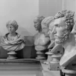 Fileira de bustos antigos de mármore em museu, em preto e branco