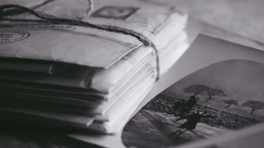 Cartas antigas empilhadas ao lado de uma fotografia em preto e branco