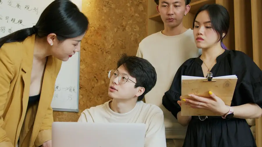 Equipe discutindo ideias em volta de um computador