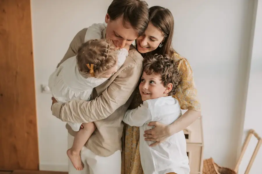 Família abraçada em casa, a gratidão que a visualização negativa ajuda a renovar