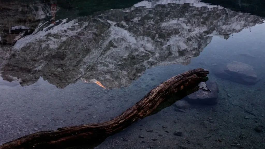 Montanha refletida nas águas calmas de um lago ao entardecer