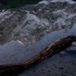 Montanha refletida nas águas calmas de um lago ao entardecer
