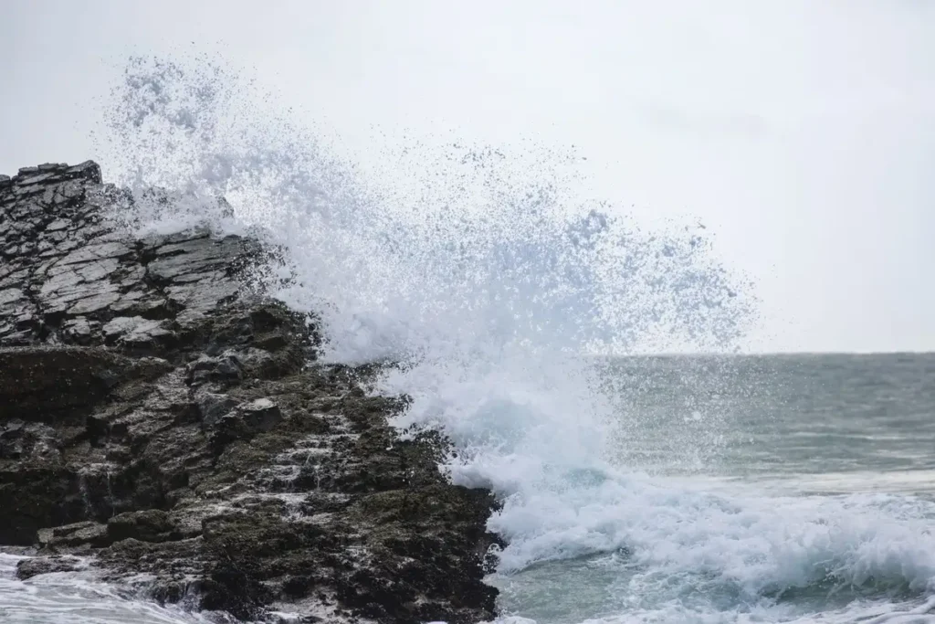Ondas fortes quebrando contra rochas firmes na costa