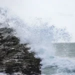 Ondas fortes quebrando contra rochas firmes na costa