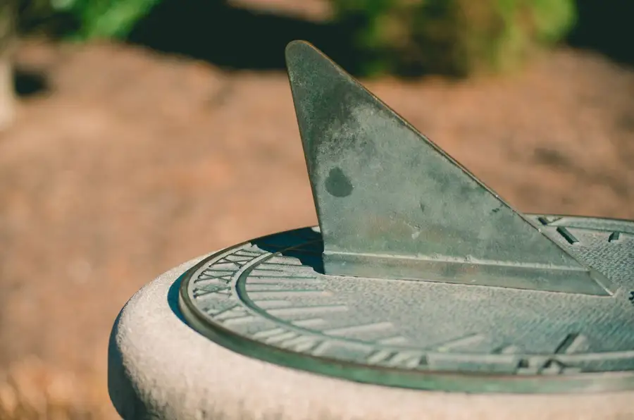 Relógio de sol de pedra num jardim, lembrete da passagem do tempo