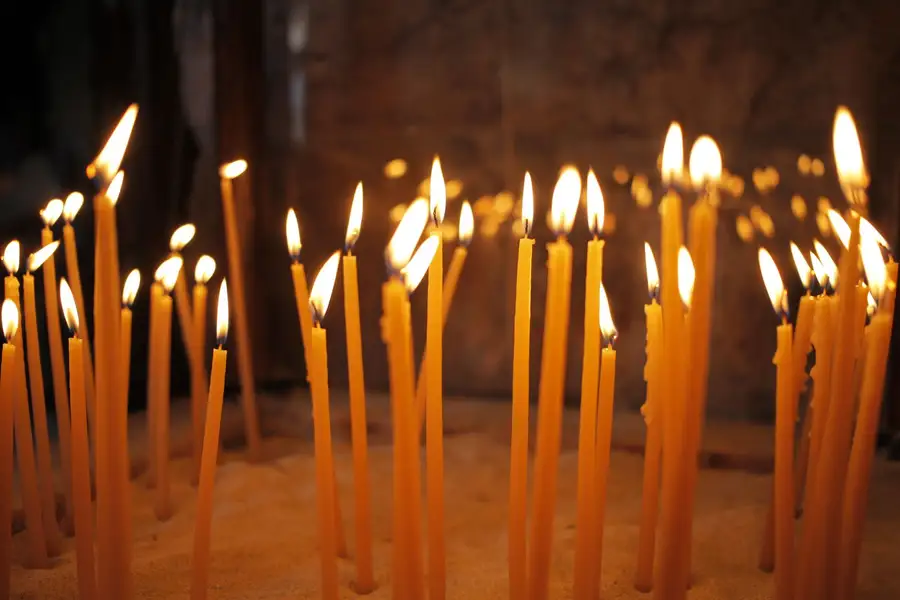 Velas finas acesas numa igreja, símbolo da fé no debate estoicismo x cristianismo